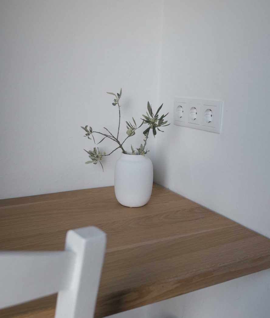 jarra branca com planta na decoração de mesa de escritório